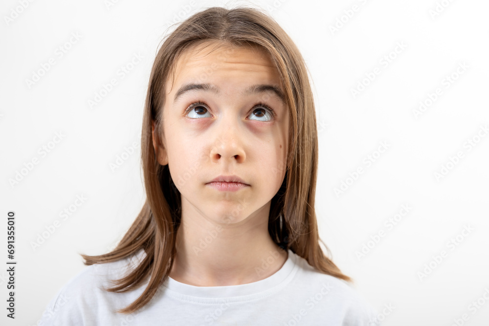 Little girl looks to the side in surprise on a white background isolated. Little girl looks to the side in surprise on a white background isolated.