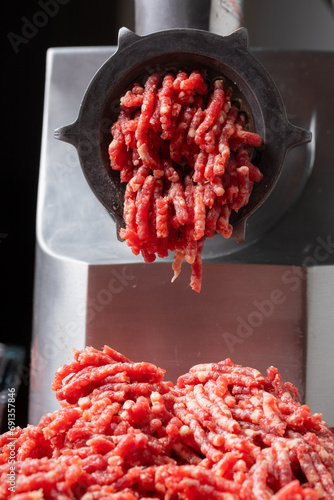 raw beef minced meat comes out of mincing machine mincer front view close up banners advertising