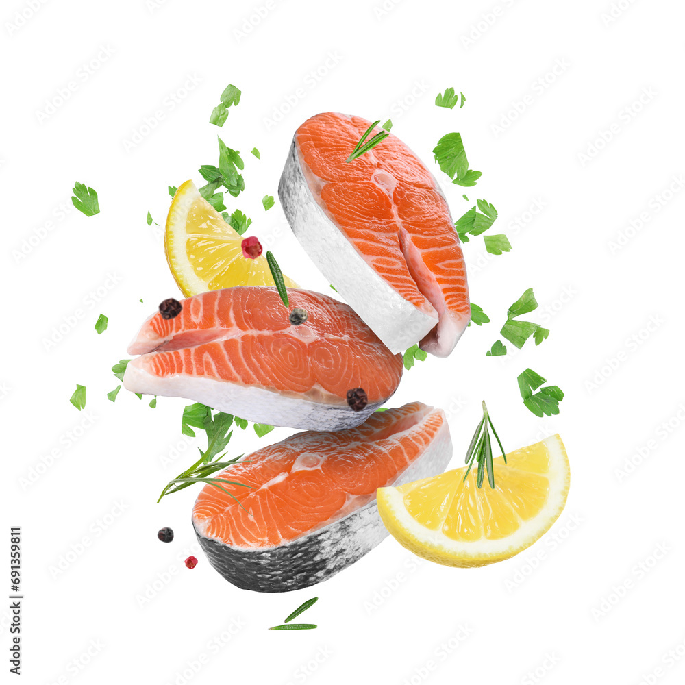 Fresh salmon steaks, spices and lemon slices falling on white background Fresh salmon steaks, spices and lemon slices falling on white background