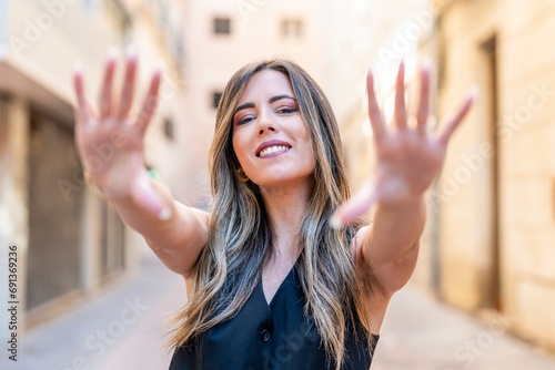 Smiling businesswoman with highlighted hair showing palm of hands photo