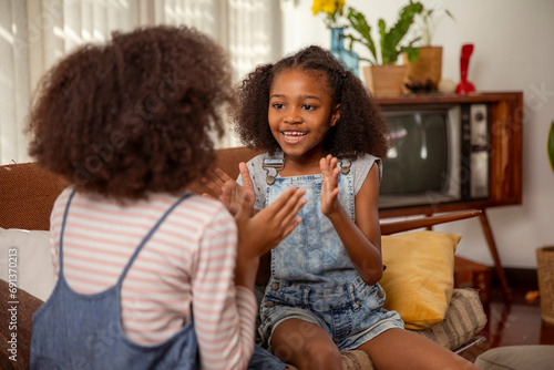 Girls playing clapping game at home photo