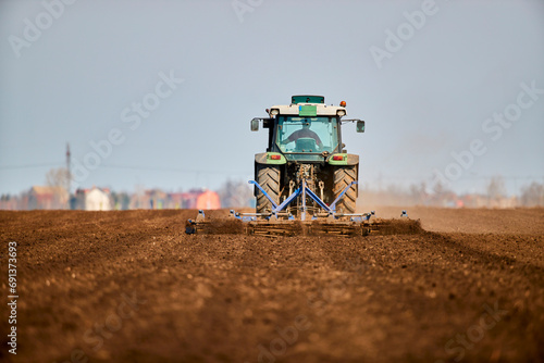 Tractor plowing field in early spring photo