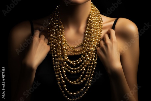 Beautiful model in a luxury gold necklace on a black background photo