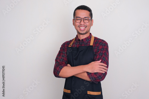 A man wearing apron smiling confident with arms crossed photo