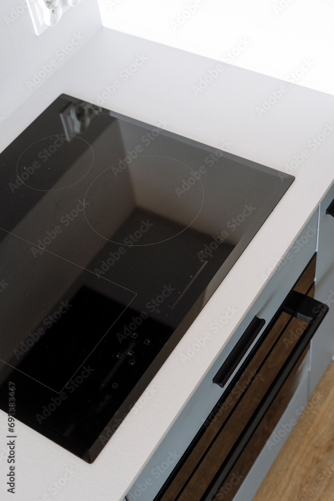 High angle shot of induction stove with control panel and clean surface in kitchen High angle shot of induction stove with control panel and clean surface in kitchen