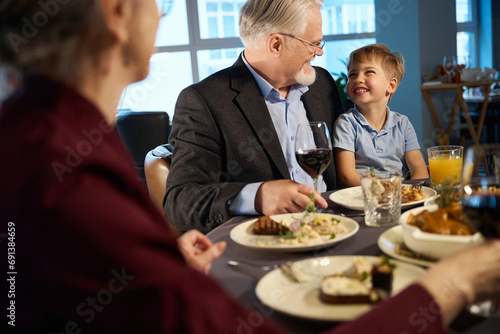 Happy old man and little boy looking at each other in the restaurant photo