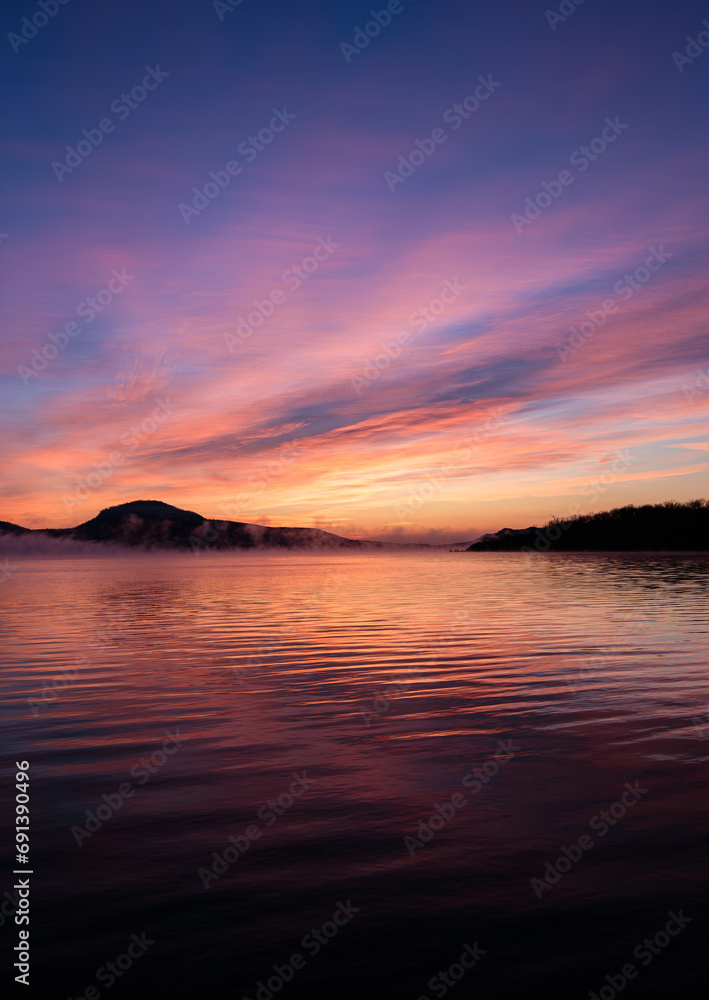 朝焼けの空が美しい湖の畔の風景。