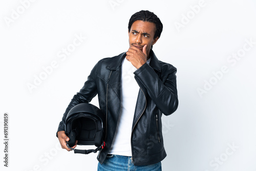 African American man with braids holding a motorcycle helmet isolated on white background looking up while smiling