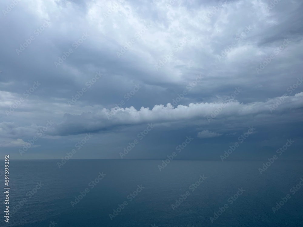 Dark rainy clouds at the sea, cloudy seascape, deep blue sea horizon