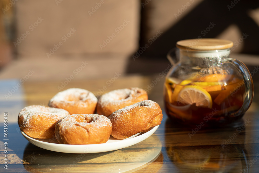 Tea with donuts on table. Delicious food in summer. Details of table in restaurant.