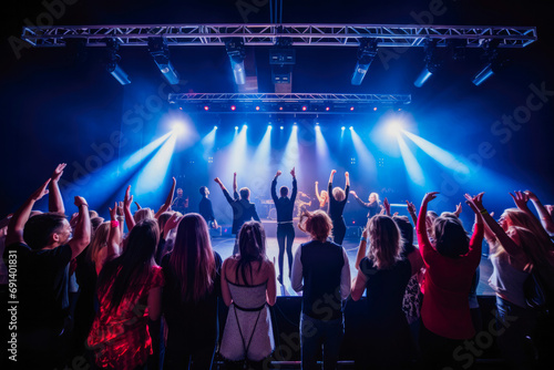 Dancing in front of the stage at the concert, festival. Enjoying the youth. Concert lights, performance, band, dancers, disco. © VisualProduction