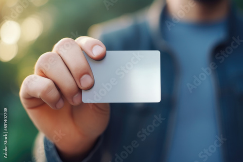 Hand holding a blank white card. The concept suggests identity or transaction.