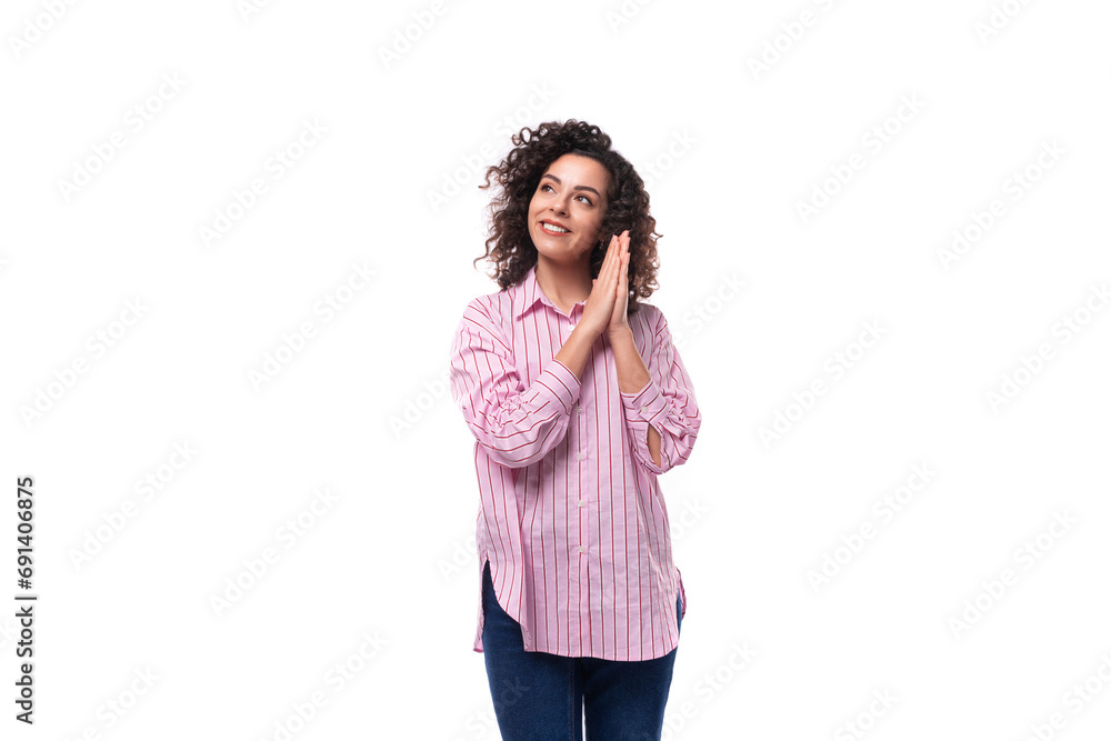 young successful european curly brunette woman in pink shirt on background with copy space young successful european curly brunette woman in pink shirt on background with copy space