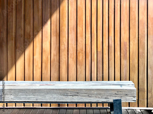 waiting area solid geometric texture wood bench with steel leg on stripe wood floor on vertical random size wood stripe background under morning sunlight shade