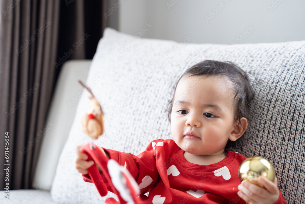 Fototapeta premium A boy wears red for a Christmas theme on sofa, cute boy, Babe.