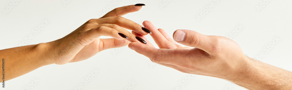 cropped view of young couple touching hands and fingers of each other on ecru background, banner cropped view of young couple touching hands and fingers of each other on ecru background, banner