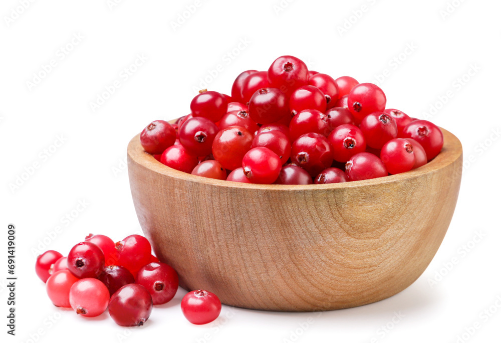 Cranberries in a wooden plate and scattered close-up on a white background. Isolated Cranberries in a wooden plate and scattered close-up on a white background. Isolated