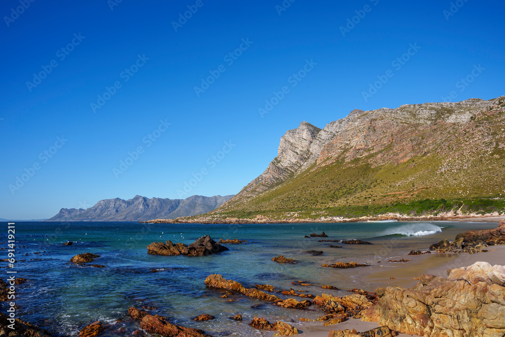 View of the gorgeous Rooi Els beach with the Kogelberg Mountains and Clarence Drive in the background. Western Cape. South Africa