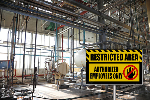 Sign with text Restricted Area Authorized Employees Only near different equipment indoors photo