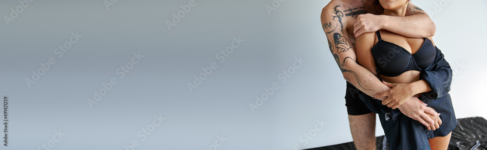 cropped view of young multicultural couple in underwear hugging on gray background, banner - obrazy, fototapety, plakaty 