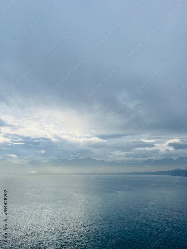 Dark clouds reflection at the sea surface, evening sea horizon
