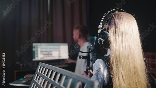 Girl sings with teacher in audio studio photo