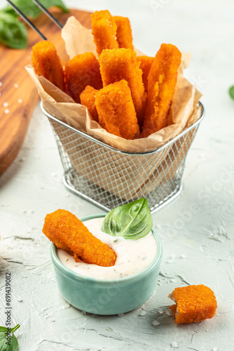 Crumbed fish sticks served with lemon and tartar sauce. vertical image. top view. copy space for text photo