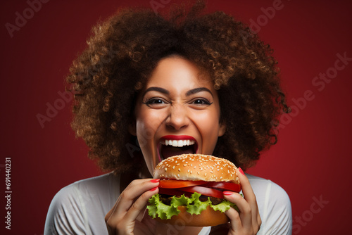 Studio Laughter  Candid Moment of a Woman Enjoying a Burger and Sharing a Smile