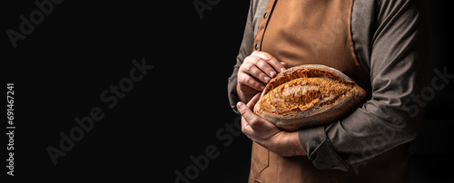 baker holds homemade bread. Long banner format. copy space for text