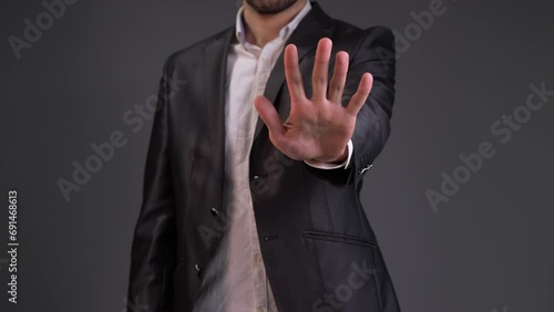 Capture a moment of decisive action with this impactful stock video featuring a man making a clear and assertive stop gesture. The scene opens with a dynamic close-up, focusing on the man's hand as he