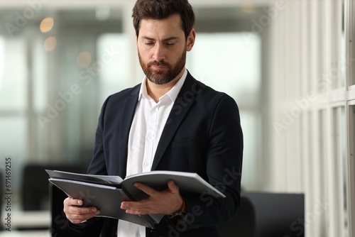 Handsome man with folder in office. Lawyer, businessman, accountant or manager