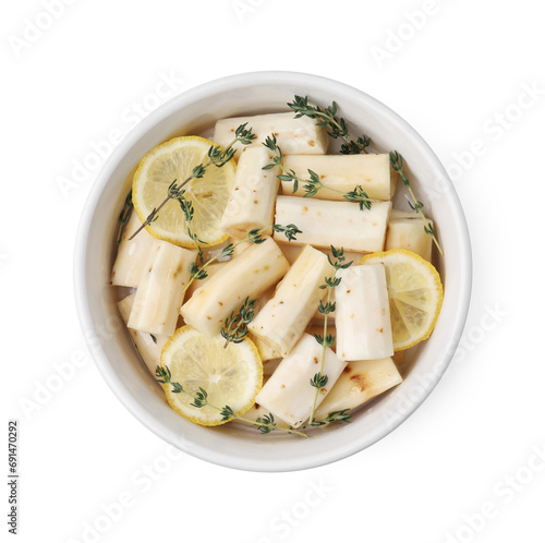Dish with raw salsify roots, lemon and thyme isolated on white, top view