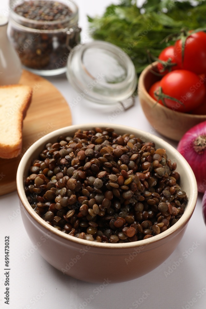 Delicious lentils in bowl served on table, closeup Delicious lentils in bowl served on table, closeup