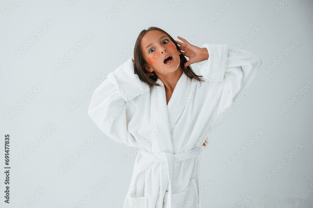 Standing and having fun. With eye patches. Conception of beauty and self care. Young girl is in the studio Standing and having fun. With eye patches. Conception of beauty and self care. Young girl is in the studio
