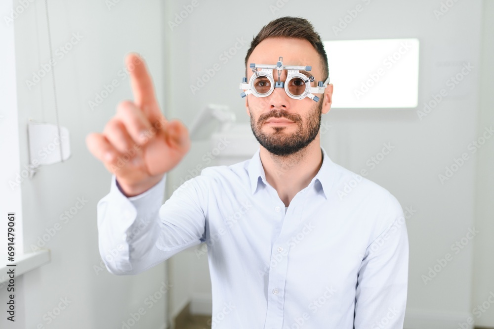 man checking up vision with special ophthalmic glasses man checking up vision with special ophthalmic glasses