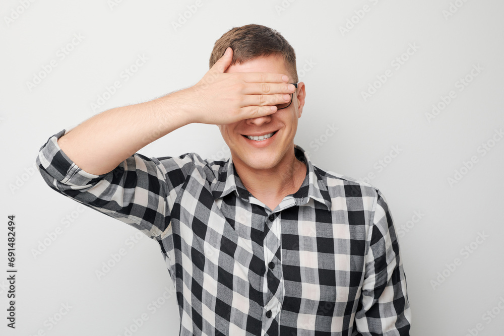 Portrait of young businessman covering eyes with hand isolated on white studio background. Portrait of young businessman covering eyes with hand isolated on white studio background.