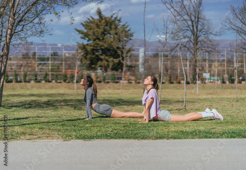 Fit, alluring sportsgirls exercising in the park, on a sunny day