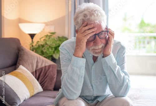 Fotografía Serious senior man sitting alone at home staring into space, old bearded man suf