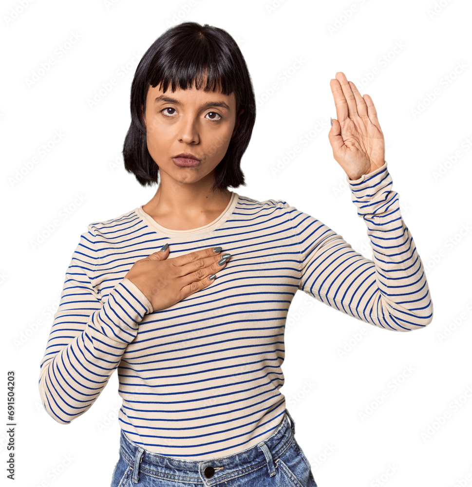 Young Hispanic woman with short black hair in studio taking an oath, putting hand on chest. Young Hispanic woman with short black hair in studio taking an oath, putting hand on chest.
