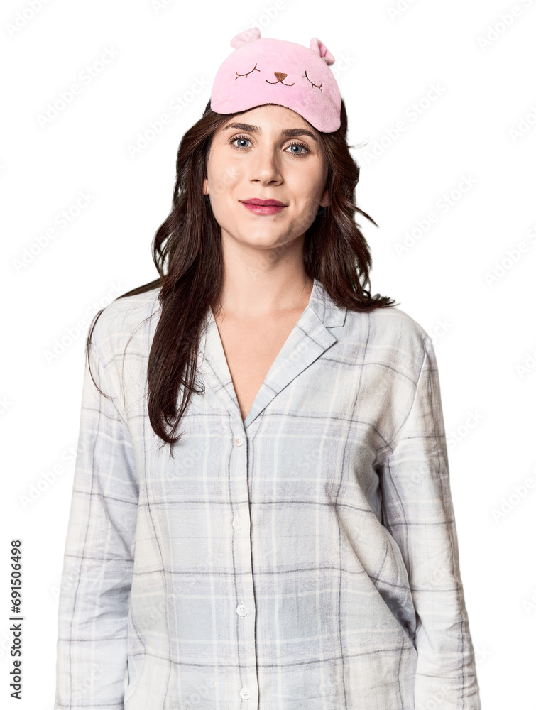 Young Caucasian woman in pajamas with sleep mask in studio Young Caucasian woman in pajamas with sleep mask in studio