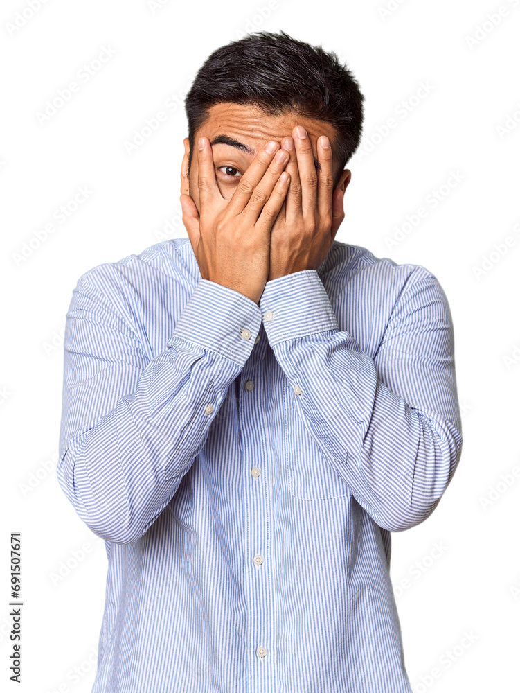 Young Chinese man in studio background blink through fingers frightened and nervous. Young Chinese man in studio background blink through fingers frightened and nervous.