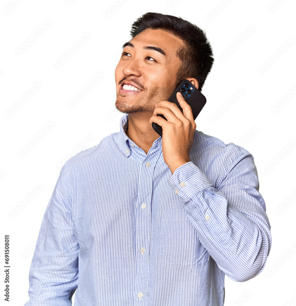 Chinese man engaged in a phone conversation in studio background Chinese man engaged in a phone conversation in studio background