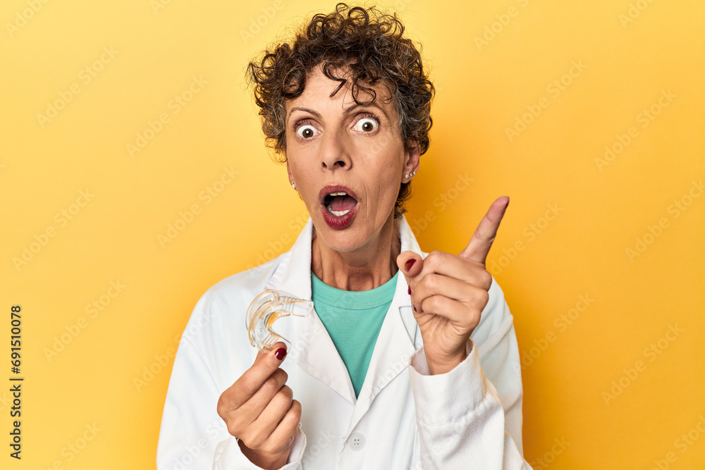 Doctor with invisible dental aligner on yellow having an idea, inspiration concept. Doctor with invisible dental aligner on yellow having an idea, inspiration concept.