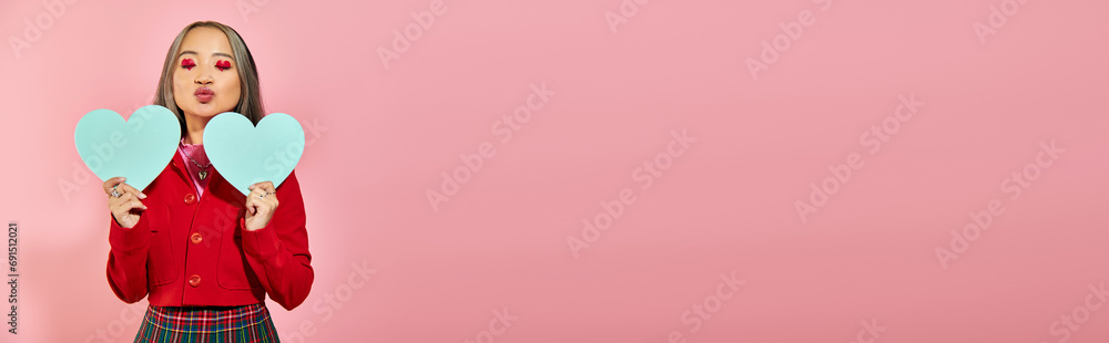 Valentines day banner, asian girl with red eye makeup holding blue carton hearts on pink, kiss Valentines day banner, asian girl with red eye makeup holding blue carton hearts on pink, kiss