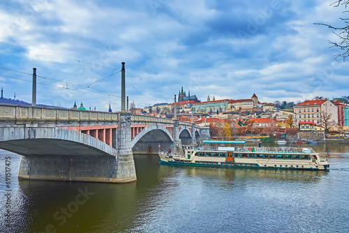 The tourist ship on Vltava River at the Manes Bridge, Prague, Czechia