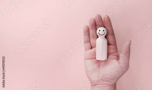Hand holding a wooden puppet and smiling, mental health concept Concept of service satisfaction assessment copy space Area for posting messages and advertising