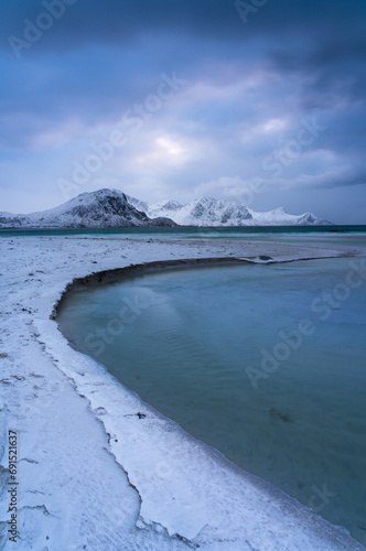 Classic scenic view in Lofoten with winter mood and snowcapped mountains and snow covered beach