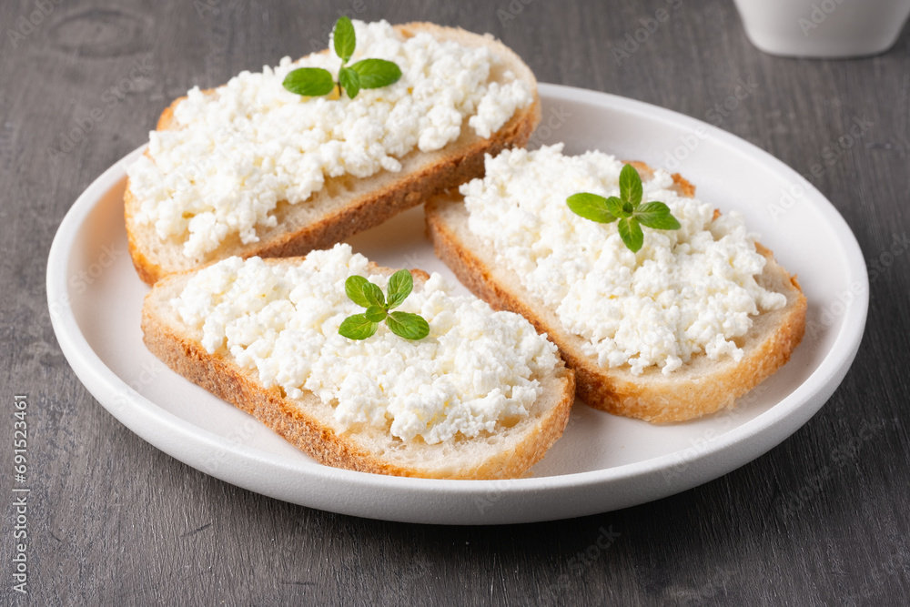 Sandwiches with cottage cheese in a plate on a wooden table
