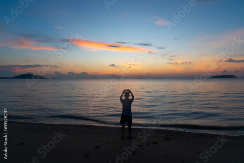 A man taking photo of sunrise in the sea at Phuket city
