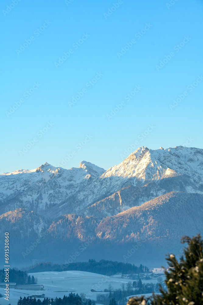 Alpine panorama with snow-covered mountains on a frosty morning at sunrise